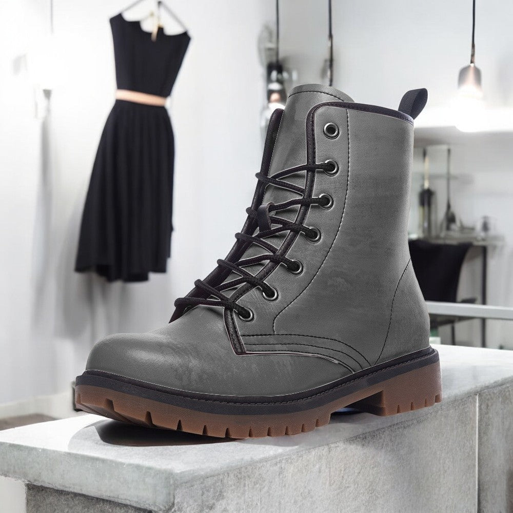 a pair of gray boots sitting on top of a cement block