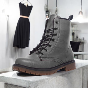 a pair of gray boots sitting on top of a cement block