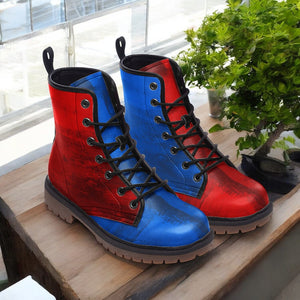 A pair of red and blue boots with black laces, placed on a wooden surface next to a potted plant.