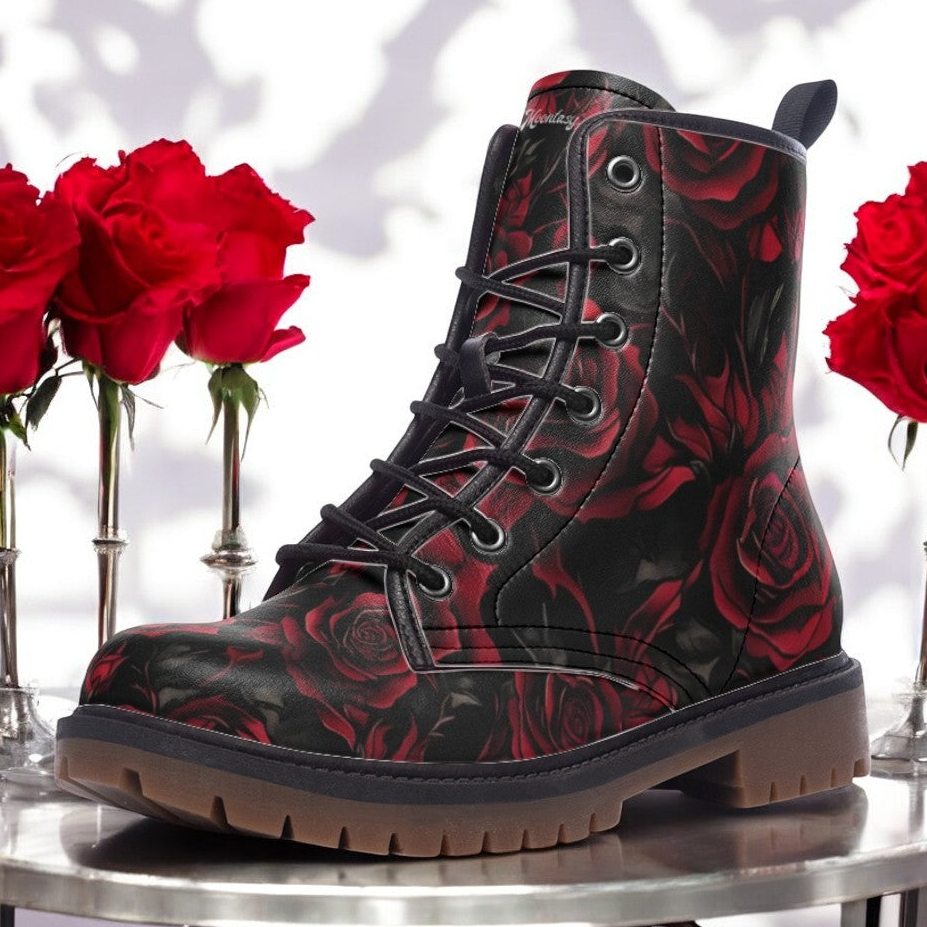 a pair of black boots with red roses on a table