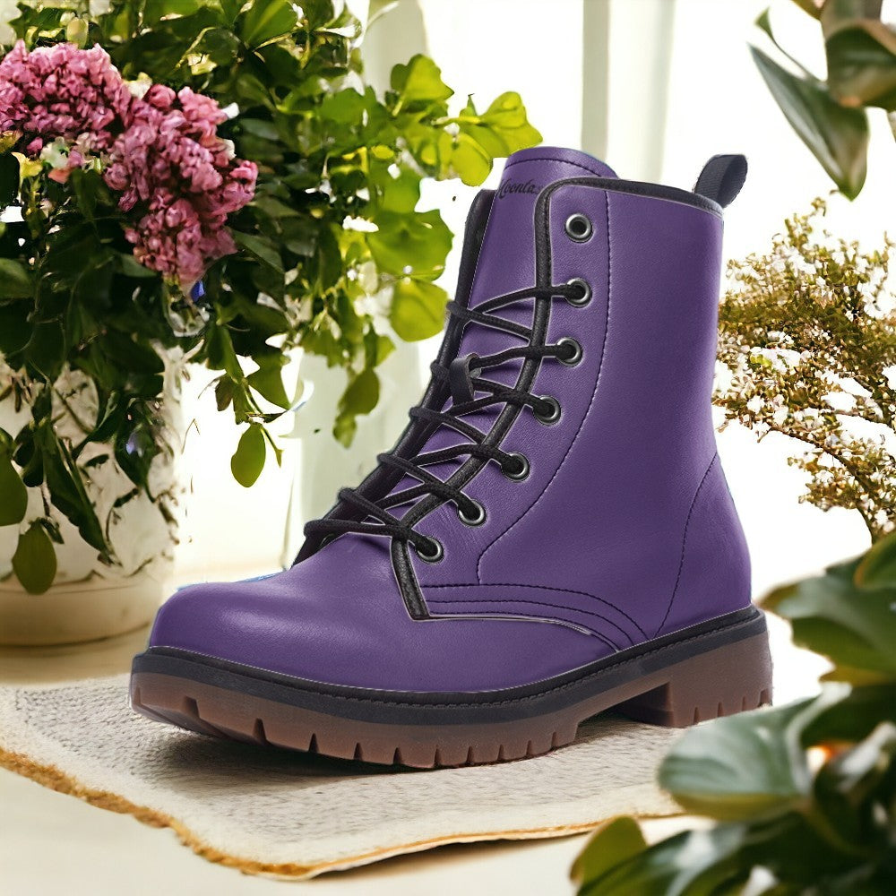 a pair of purple boots sitting next to a potted plant