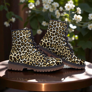 A pair of leopard print boots is displayed on a wooden surface, with white flowers visible in the background.