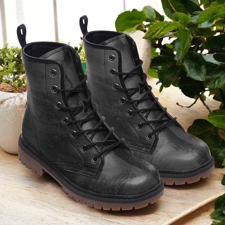 a pair of black boots sitting on top of a wooden table