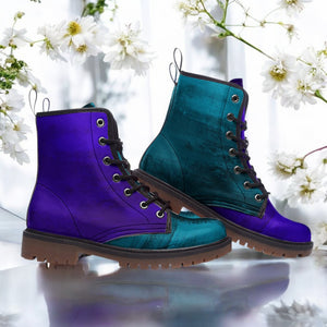 A pair of purple and teal combat boots with black laces, set against a backdrop of white flowers.